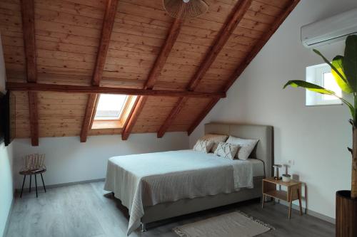 a bedroom with a bed and a wooden ceiling at Apartments with swimming pool Bacici, Krka - 24721 in Drinovci
