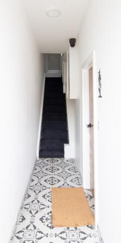 a hallway with a staircase with a rug on the floor at Best 2BR Flat in Cardiff Near Town Centre in Cardiff
