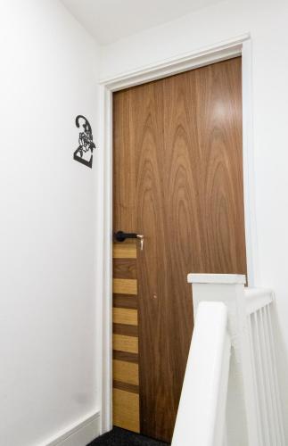 a wooden door in a room with white walls at Best 2BR Flat in Cardiff Near Town Centre in Cardiff