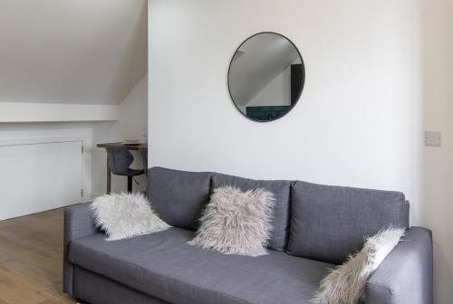 a grey couch with a mirror on the wall at Best 2BR Flat in Cardiff Near Town Centre in Cardiff