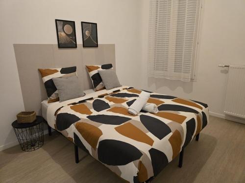 a black and white bed in a room at Appartement chaleureux de 2 chambres in Courcouronnes