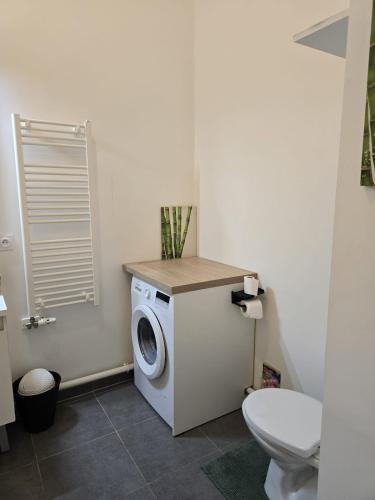 a washing machine in a bathroom with a toilet at Appartement chaleureux de 2 chambres in Courcouronnes