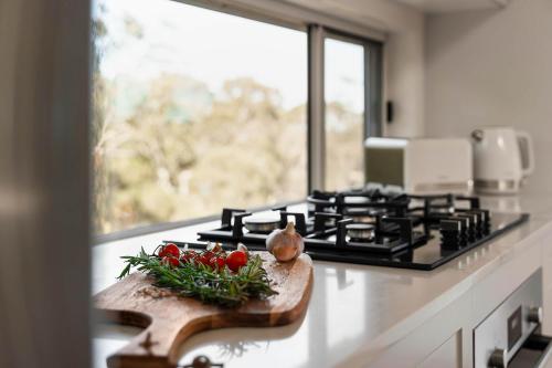 a kitchen counter with a cutting board with tomatoes on it at Highview Escape in Mount Victoria