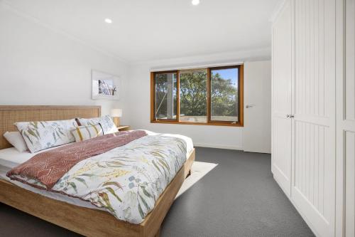 a bedroom with a bed and a window at Lookout and Sea - Beachfront Bliss in McCrae in McCrae