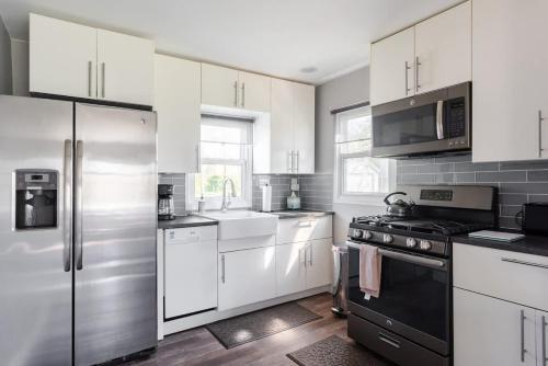 eine Küche mit weißen Schränken und schwarzen Geräten in der Unterkunft Corporate insurance or family vacation in Wolverine lake in Walled Lake