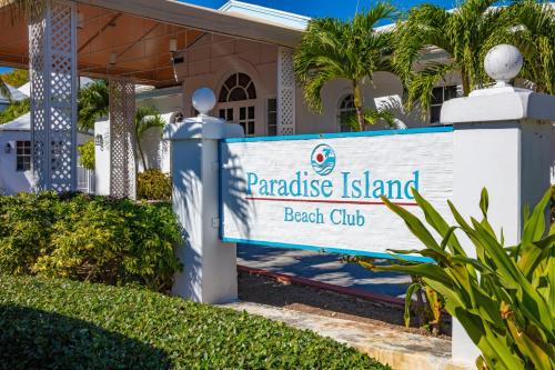 a sign for paradise island beach club in front of a house at Paradise Island Beach Club in Creek Village