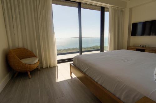 a bedroom with a bed and a large window at Penthouse At Arihini West Bay in Coxen Hole