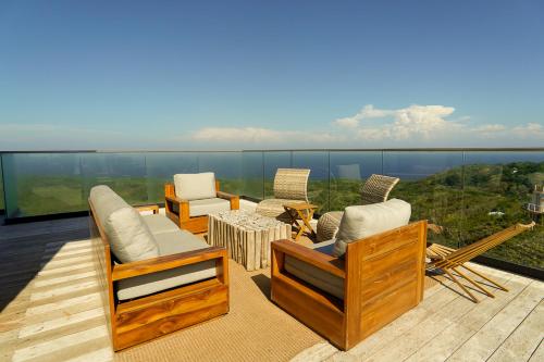 a patio with chairs and a table on a balcony at Penthouse At Arihini West Bay in Coxen Hole