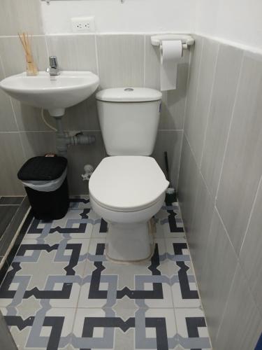 a bathroom with a toilet and a sink at Vista Farallones Hostel in Jardin