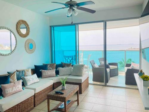 a living room with a couch and views of the ocean at Departamento con piscina 8 in Salinas