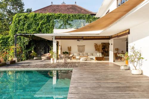 an external view of a house with a swimming pool at IBU The Sanctuary by OXO in Ubud