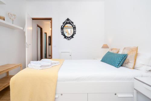 a white bedroom with a bed with a yellow blanket on it at Renovated 3BR Apt Near City Hotspots with Great Value in Porto