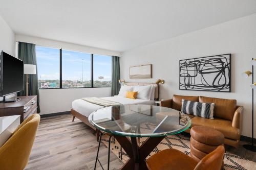 a hotel room with a bed and a glass table at Lodgeur Upper Kirby, Houston - Close to Greenway Plaza, Galleria, Montrose in Houston