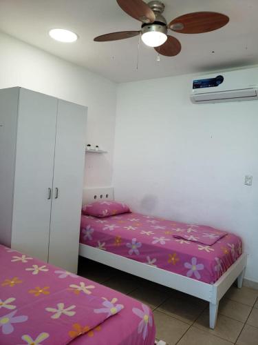 a bedroom with two beds and a ceiling fan at Departamento con piscina 8 in Salinas