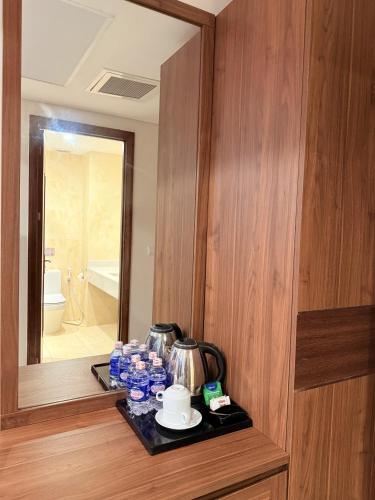 a room with a mirror and a tray with water bottles at Lenid Ocean View Hotel in Nha Trang