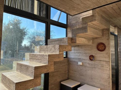 a stone wall with a staircase in a bathroom at Cabañas Litueche 1 in El Rosario