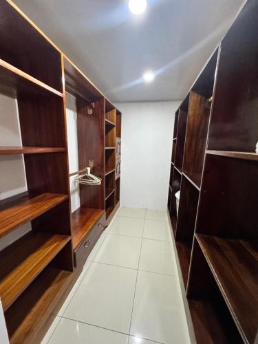 a walk in closet with wooden shelves and white tiles at Casa Bela in Parrita