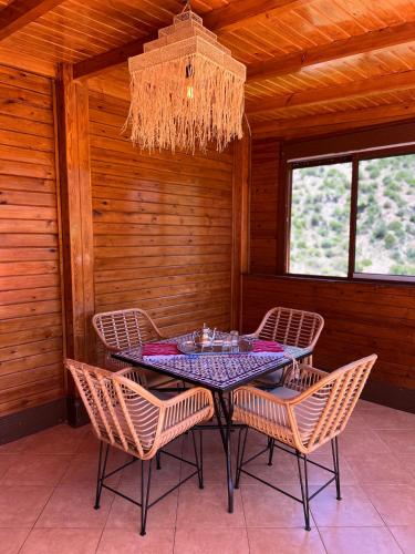 a dining room with a table with chairs and a chandelier at Hotel nabil in Akchour