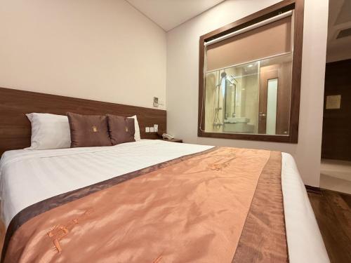 a bedroom with a large bed with a large mirror at Lenid Ocean View Hotel in Nha Trang
