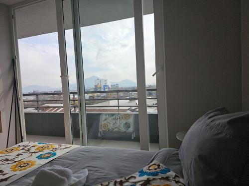 サンティアゴにあるCentral apartment in historic Barrio Yungay, en pleno centro de Santiagoのベッドと大きな窓のある寝室