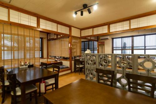 a dining room with tables and chairs and windows at Blue Cove Terrace in Miyako Island