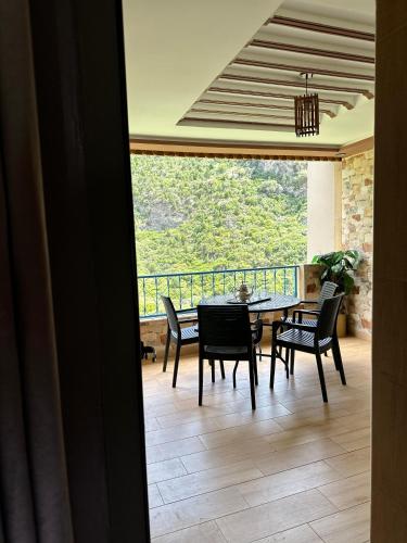 a dining room with a table and chairs and a balcony at Hotel nabil in Akchour