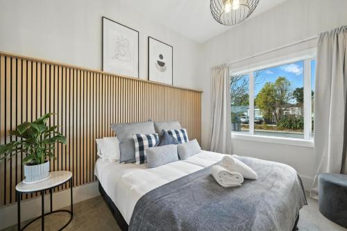 une chambre avec un grand lit et une fenêtre dans l'établissement Albemarle Villa, à Christchurch