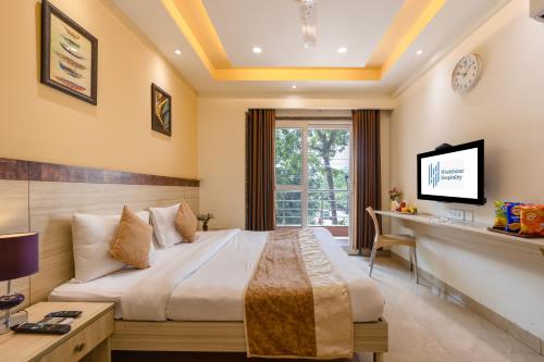 una habitación de hotel con una cama y un escritorio en Windchime 853, en Gurgaon