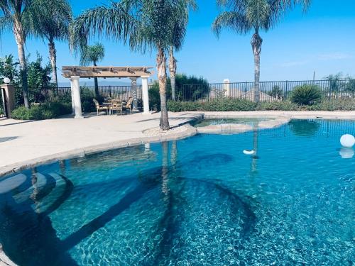a swimming pool with a gazebo and palm trees at High End Triplex with Pool in Riverside