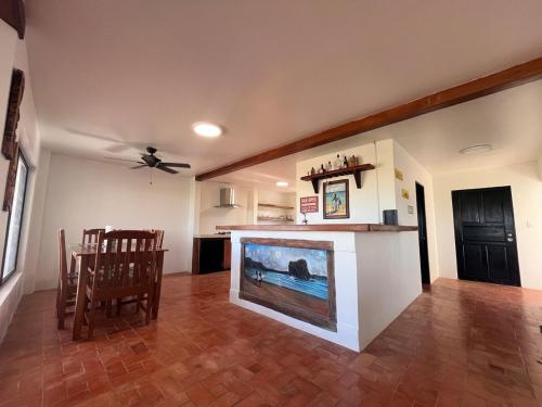 a living room with a fireplace and a dining table at Surfers bungalow 5 min walk to the beach in Tamarindo