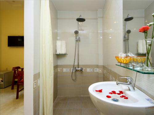 a bathroom with a sink and a shower with roses on it at Fireworks Homestay in Hoi An