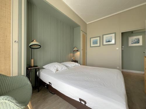 une chambre avec un grand lit blanc et une chaise dans l'établissement Appartement Standing Centre Arcachon, Résidence Grand Hôtel, 6 pers, Plages et Commerces à Proximité - FR-1-474-5, à Arcachon