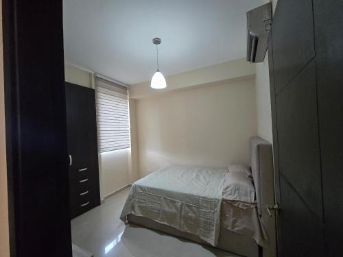 a small bedroom with a bed and a window at Acogedor y Centrico Apto 2hab-1baño in Maracaibo
