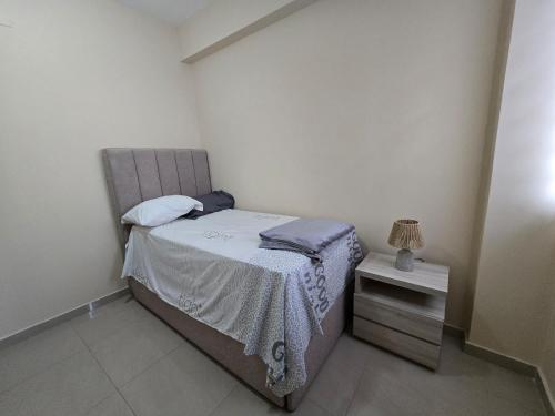 a small bedroom with a bed and a side table at Acogedor y Centrico Apto 2hab-1baño in Maracaibo