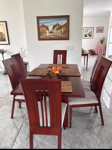 a dining room table and chairs with fruit on it at Encenillos del Manantial in Circasia