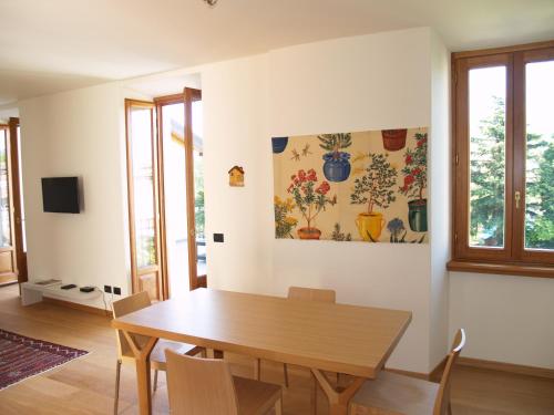 a dining room with a wooden table and chairs at Casa Botta - Luino Lago Maggiore in Luino