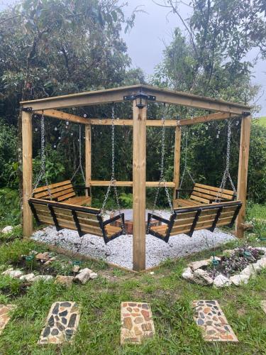 a swing set with benches in a yard at Cabernet Cabaña - La Cava Lodge in Medellín