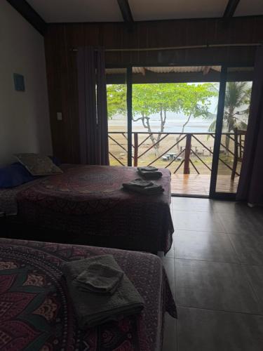 a bedroom with two beds and a view of the ocean at Casa Nova at La Escapadita in Esterillos