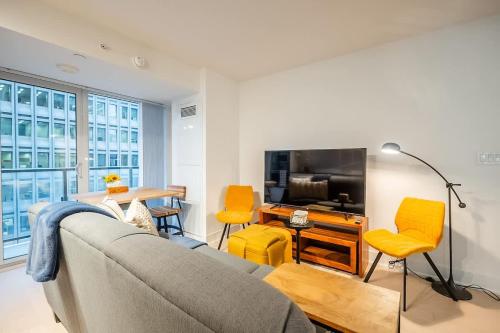 un salon avec un canapé et une télévision dans l'établissement Stylish Stay with City Views, Pool and Gym, à Toronto