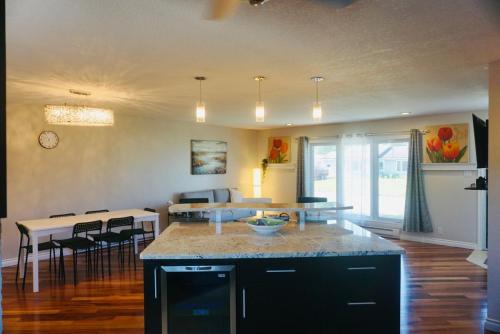 a kitchen and living room with a table and chairs at Spacious 4BR Family Home - Wine Fridge, Patio, Parking in Thompson