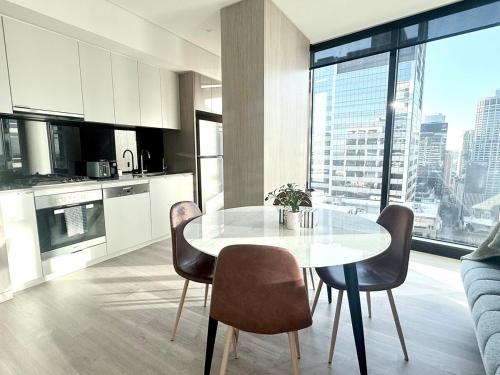 a kitchen with a table and chairs in a room at Sydney CBD New 2 bedroom Condo with amazing view Pool Gym 2 in Sydney