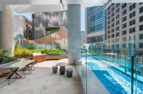 an outdoor patio with a pool and tables and chairs at Sydney CBD New 2 bedroom Condo with amazing view Pool Gym 2 in Sydney