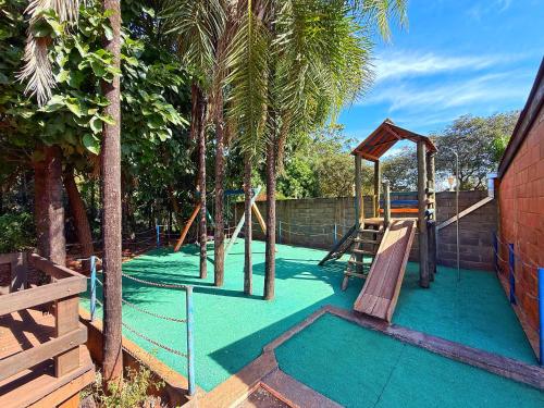 a playground with a slide and a swing set at Pousada Recanto Solar dos Pássaros in Olímpia