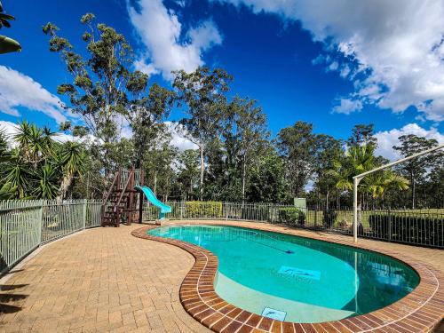 a swimming pool with a slide and a playground at JJJ's Ranch Farm 1 by Tiny Away in Koolboo