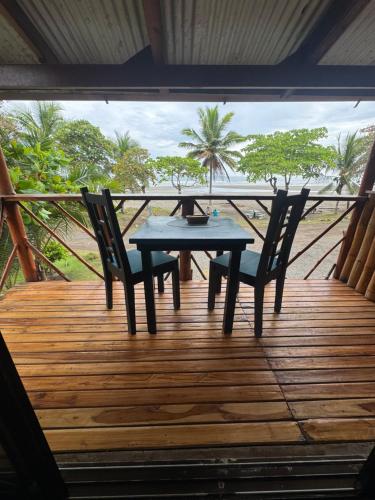 a table and two chairs on a wooden deck at Casa Nova at La Escapadita in Esterillos