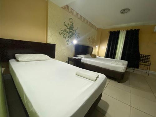 a hotel room with two beds and a window at Hotel Euroasia By BLUEBOOKERS in Angeles