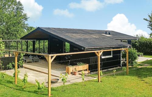 a large black house with a wooden deck at 3 Bedroom Cozy Home In Vinderup in Vinderup