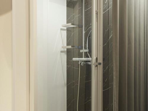 a bathroom with a shower with a glass door at CROSS Life Hakata Yanagibashi in Fukuoka