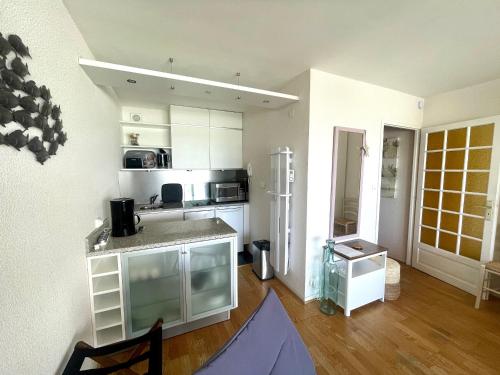 une cuisine avec des armoires blanches et un comptoir dans l'établissement Studio avec balcon, WIFI, et parking proche plage - FR-1-92-616, à Les Sables-dʼOlonne