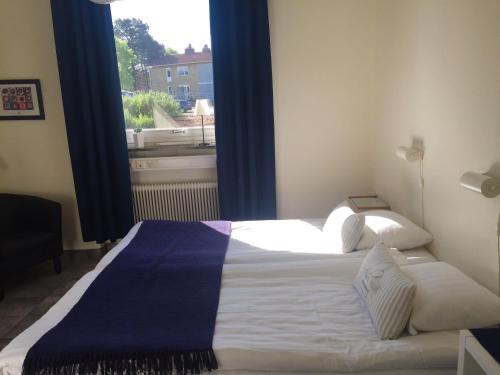 a bedroom with a large bed with a window at Aurora Bed & Breakfast in Simrishamn